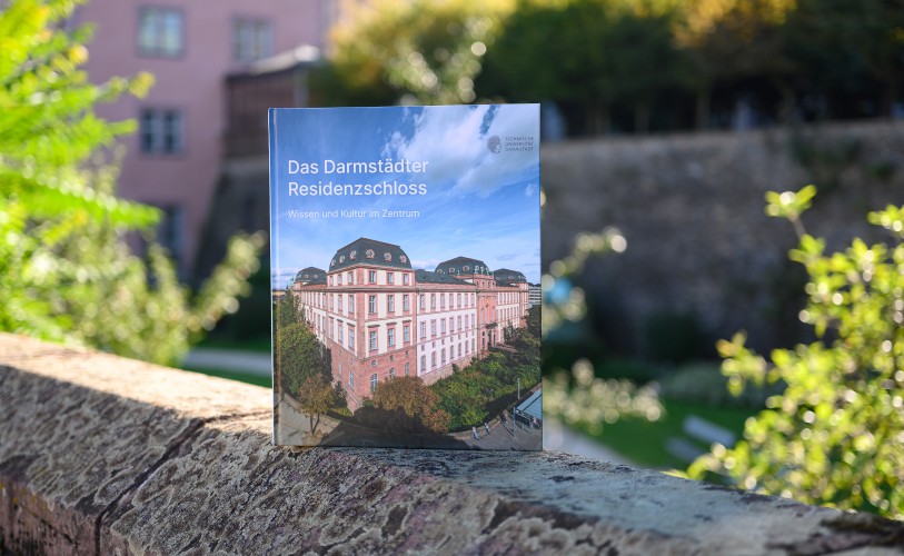 Foto des Bildbands „Das Residenzschloss Darmstadt“ auf der Mauer des Schlossgrabens.